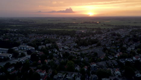 Aerial-of-quiet-town-at-sunrise-with-traffic-driving-in-the-distance