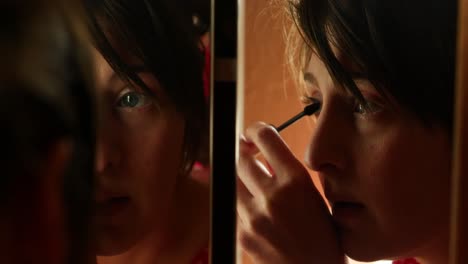 Dark-moody-clip-of-beautiful-young-early-20s-or-30s-women-lady-girl-putting-mascara-makeup-on-eyes-in-split-mirror-bathroom-cinematic-close-shot