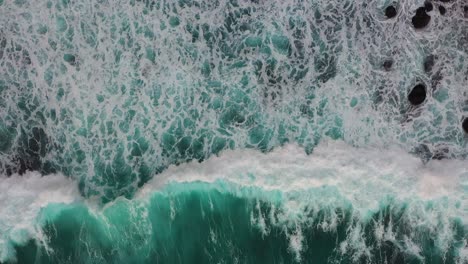 Aerial-shot-of-big-turquoise-ocean-waves-crashing-coastline-of-Nusa-penida-island,-one-of-the-tourist-attractions-of-Bali-island-Crystal-beach-kelingking-beach-angle-billabong-broken-beach