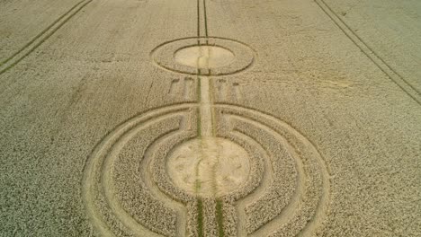 Aerial-view-above-crop-circle-message-on-UK-sydmonton-wheat-field-farmland-low-drone-fly-over