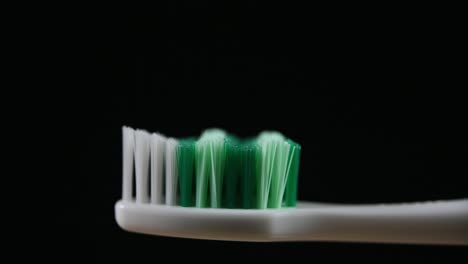 A-toothbrush-zoomed-out-with-a-dark-background-revealing-bristles-and-the-handle