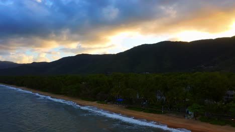 Waves-on-the-beautiful-Palm-Cove-in-Cairns,-Australia-at-sunset--Aerial