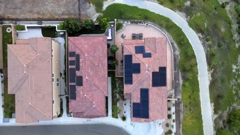 Aerial-top-down-shot-of-solar-panels-covering-house-roof-in-downtown-suburb