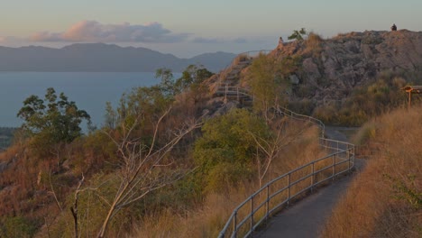 Travelers-Walk-On-Stair-Pathway-Of-Castle-Hill-Lookout-With-Magnetic-Island-In-Horizon