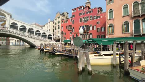 Riding-a-Vaporetto-Away-From-Rialto-Bridge-Pier,-View-Of-Venetian-Houses