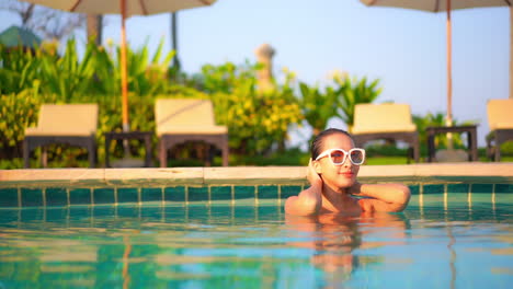 Urlaubsstimmung---Frau-Berührt-Nasses-Haar-Im-Schwimmbad-Bei-Farbenprächtiger-Sonnenuntergangsbeleuchtung-In-Einer-Exotischen-Lounge-Im-Hotel-Von-Miami