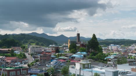 Lapso-De-Tiempo-De-Nubes-Moviéndose-Sobre-Casas-Residenciales-Con-Iglesia-En-El-Condado-De-Geumsan,-En-La-Provincia-De-Chungcheong-Del-Sur,-Corea-Del-Sur