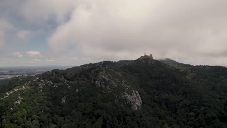 Hilltop-Pena-Palace-against-cloudy-sky,-Natural-Park-of-Sintra,-Portugal