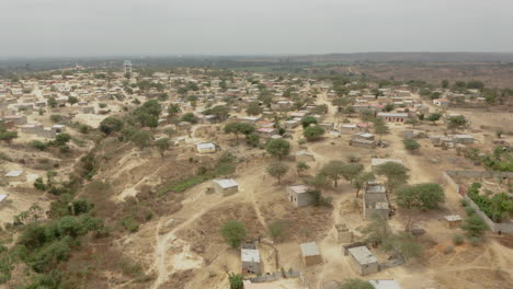 Angola,-Flying-over-a-small-adobe-village,-Caxito,-Bengo,-Africa