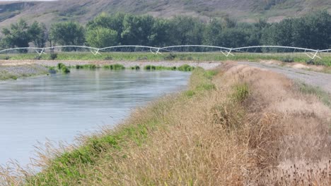 Irrigation-canal-and-pivot-bring-water-to-crops-in-arid-prairie-valley