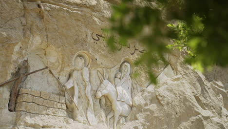 Christliche-Schnitzereien-Außerhalb-Der-Höhlenkirche-In-Kairo-Ägypten-Mit-Blättern-Im-Vordergrund