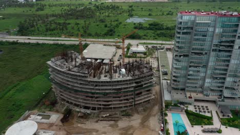 Birds-eye-view-dolly-in-over-building-under-construction-at-day,-pan-shot