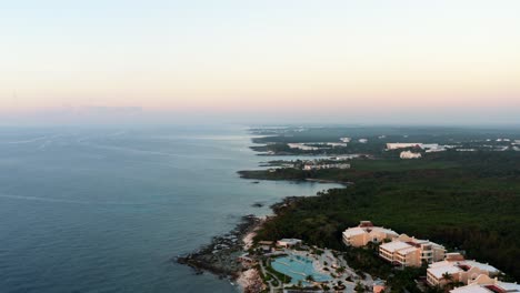Beautiful-aerial-drone-bird's-eye-view-of-the-stunning-playa-del-carmen-beach-coastline-with-various-resorts-along-it-on-a-colorful-vivid-summer-morning-during-sunrise-in-Riviera-Maya,-Mexico