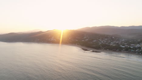 Sunrise-aerial-over-Sayulita-Mexican-Pacific-coast-with-sun-flare,-4K