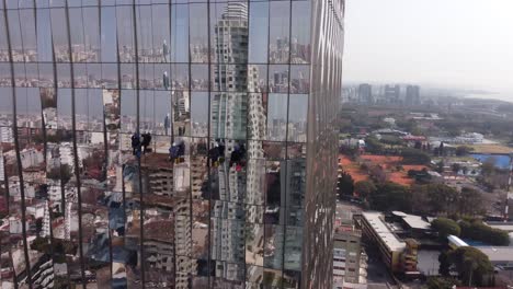 Ungewöhnliche-Luftdrohnenansicht-Von-Fensterputzern-Auf-Dem-Glasigen-Wolkenkratzer-Von-Buenos-Aires