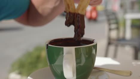 Person-Dipping-Sweet-Churros-In-A-Hot-Chocolate-During-Breakfast