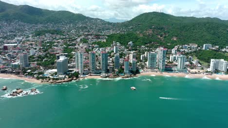 Birds-eye-view-tracking-shot-of-beautiful-Acapulco-coast-beach-in-summer