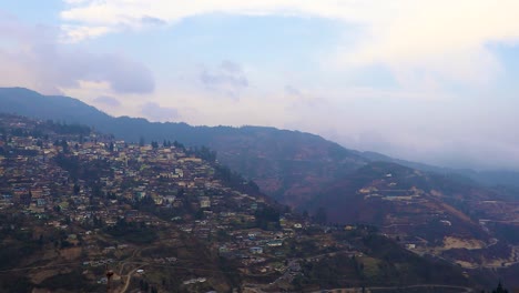 Blick-Auf-Die-Urbanisierung-Der-Stadt-Von-Der-Hügelspitze-Mit-Einer-Riesigen-Konstruktion-Am-Tag-Aus-Einem-Flachen-Winkelvideo-Wird-In-Bomdila-Arunachal-Pradesh,-Indien,-Aufgenommen