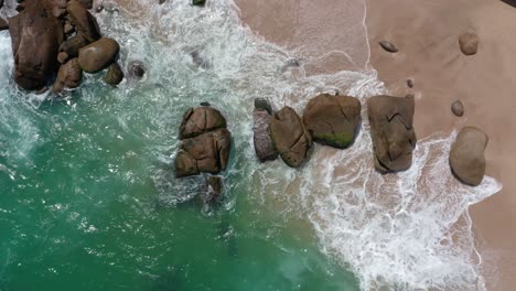 top-down-view-of-beautiful-rocks-at-beach-seaside-with-ocean-wave-crashing