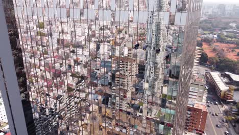 Aerial-track-shot-showing-group-of-industrial-window-cleaner,washing-mirrored-skyscraper-during-sunny-day---Maintenance-Worker-in-high-altitude