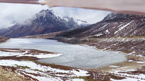 frozen-sela-lake-with-snow-cap-mountains-and-bright-blue-sky-at-morning-from-flat-angle-video-is-taken-at-sela-tawang-arunachal-pradesh-india
