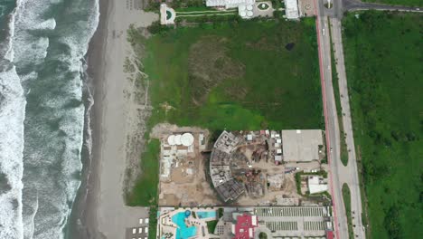 Aerial-above-construction-site-near-seaside-beach-at-Acapulco,-Mexico