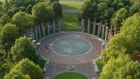Aerial-tilt-down-reveals-carillon-pillars-and-people-doing-yoga