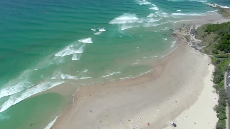 Aerial-drone-view-of-sandy-beach-full-of-people-on-a-sunny-day