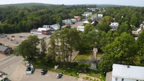 Aerial-footage-of-Skowhegan,-Maine-downtown-with-Indian-statue-in-the-foreground