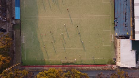 Aerial-top-down-moving-up-view-of-football-players-playing-the-match-at-the-football-ground