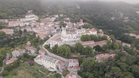 Cinematic-aerial-orbiting-shot-capturing-the-residence-town-palace-of-Sintra-on-a-foggy-weather