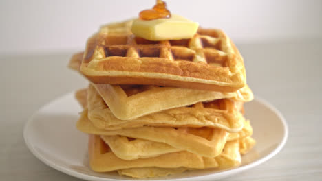 pouring-honey-or-maple-syrup-on-stack-of-waffles