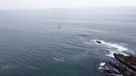 Un-Pequeño-Bote-Solitario-Flotando-Frente-A-La-Costa-De-Laguna-Beach-En-California-En-Un-Día-Nublado