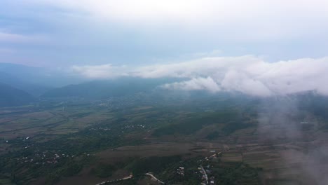 White-Clouds-And-Fog-Over-Village,-Fields,-And-Mountains-Near-Sairme-In-Georgia