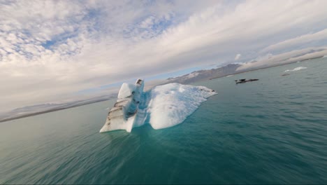 Vuelo-Cercano-Sobre-Un-Iceberg-Flotando-En-Un-Lago-Glaciar-En-Islandia