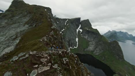 Group-of-hikers-on-top-of-high-mountain-in-Norway,-fly-around-FPV-shot