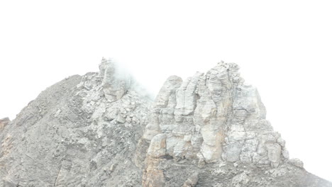 Luftaufnahme-Eines-Großen-Felsens-Auf-Der-Bergspitze,-Der-Von-Dichtem-Nebel-Bedeckt-Ist