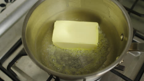 Placing-full-pack-of-New-Zealand-butter-into-hot-cooking-pot-for-melting