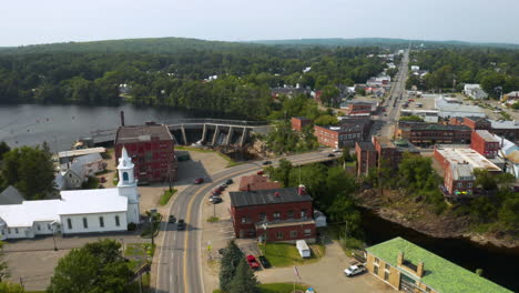 Aerial-footage-of-Skowhegan,-Maine-downtown-with-Kennebec-River-and-Dam-in-foreground