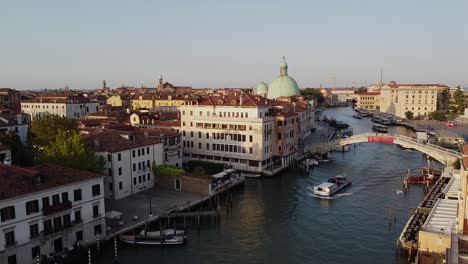 Rising-aerial-drone-shot-over-a-canal-in-Venice,-Italy