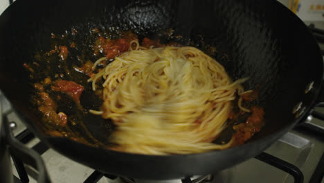 Mixing-pasta-with-bolognese-sauce-inside-a-frying-pan