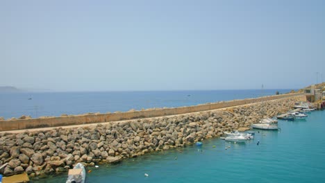 Pequeños-Botes-Amarrados-Por-El-Malecón-En-El-Mar-Bajo-La-Luz-Del-Sol