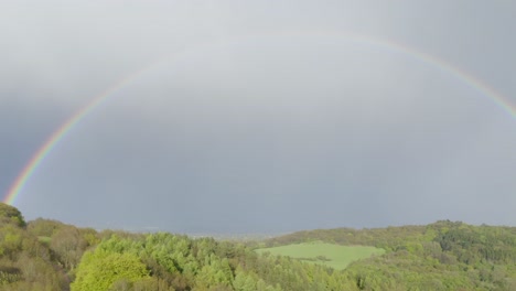 A-fully-formed-rainbow-over-the-landscape-of-green-hills-of-Clent-Hills-in-Worcestershire