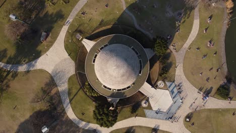 Luftaufnahme-Von-Oben-Nach-Unten-Mit-Rundem-Dach-Des-Berühmten-Planetariums-In-Buenos-Aires---Aufsteigender-Schuss-Mit-Ruhenden-Menschen-Im-Freien-Im-Park