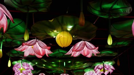 Pink-flower-lights-hang-from-a-ceiling-as-yellow-lights-create-the-perception-of-movement