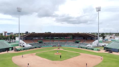 San-pedro-de-macoris,-DR---March-12,-2021---View-of-drone-ascending-showing-minor-league-team-practice-game,-"tetelo-vargas"-stadium-in-san-pedro-de-macoris,-dominican-republic