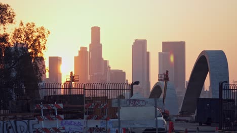 Filmischer-Schuss-Bei-Sonnenaufgang-über-Der-Sanierung-Der-6th-Street-Bridge-In-La-Und-Mit-Der-Skyline-Von-Los-Angeles-Am-Horizont