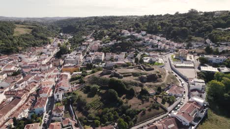Umkreisende-Aufnahme,-Die-Die-Ruinen-Des-Castelo-De-Alcobaça-Und-Das-Stadtbild-Der-Gemeinde-In-Portugal-Einfängt