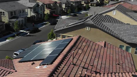 Low-angle,-solar-panels-on-houses,-green-renewable-concept,-aerial-in-Tustin,-California
