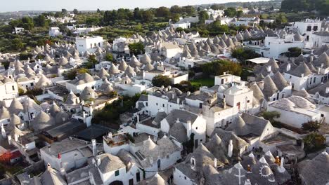 Cinematic-drone-shot-approaching-ancient-city-Alberobello,-Italy